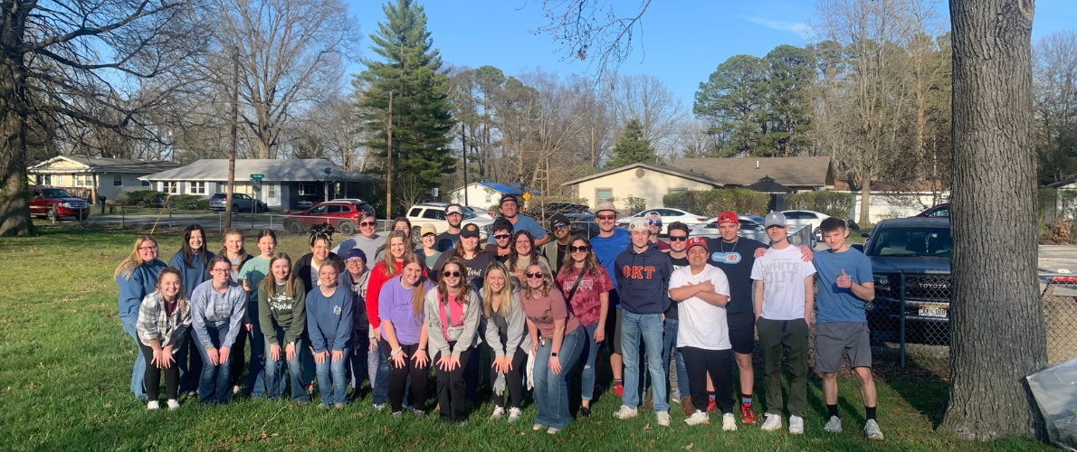 Fraternity and sorority staff members pose together before a community event